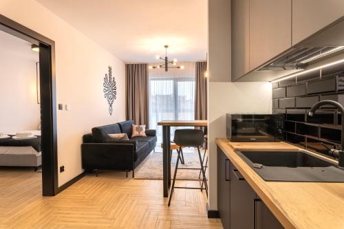 a kitchen and living room with a table and a couch at Stylchyn 90 Apartamenty nad Jeziorem Czorsztyńskim in Kluszkowce