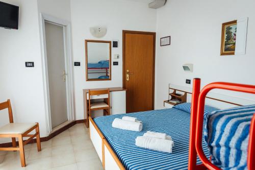 Hotel Montecarlo في ريميني: غرفة نوم عليها سرير وفوط