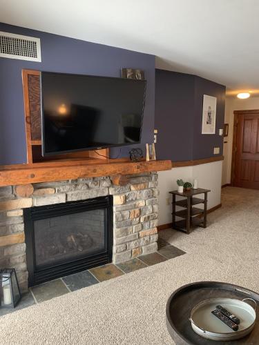 a living room with a fireplace with a flat screen tv at Highland House 207 Slopeside, Village Area, Ski in out in Snowshoe