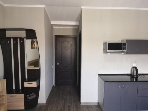 a kitchen with a black door and a microwave at Opera Apart Hotel in Kyiv