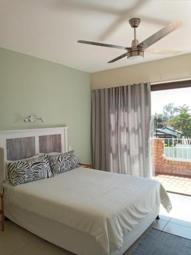 a bedroom with a bed and a ceiling fan at Rockview Guest House in Port Edward