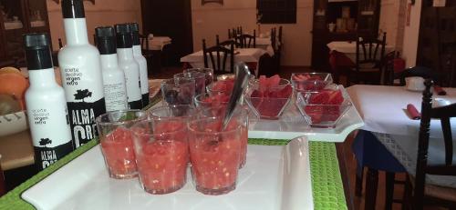 a table topped with glasses with strawberries and bottles of wine at Hotel Rural Posada Los Caballeros in Almagro