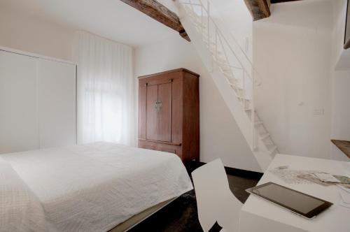a white bedroom with a bed and a staircase at Salvadonica in San Casciano in Val di Pesa