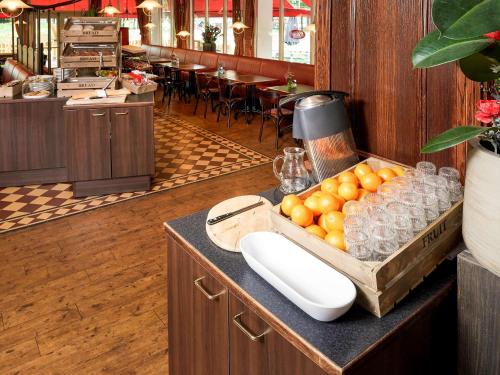 a table with a box of oranges on a counter at ibis Tilburg in Tilburg