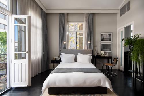 a bedroom with a large bed and a window at Hotel Montefiore in Tel Aviv