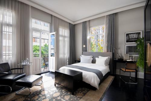 テルアビブにあるホテル モンテフィオーレのベッドルーム(キングサイズベッド1台付)、リビングルームが備わります。