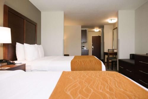 a hotel room with two beds and a desk at Comfort Inn & Suites in Custer