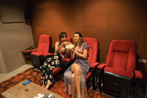 two women sitting in a theater with a plate of food at Whale Hua Hin - SHA Plus in Hua Hin