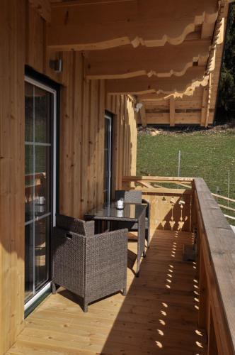 a wooden deck with a table and chairs on it at Ferienwohnungen Holzidylle in St. Wolfgang