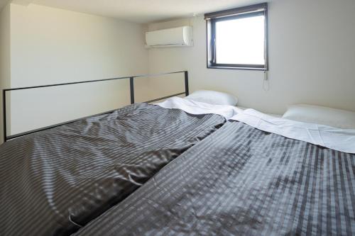 a large bed in a room with a window at Hotel Tohko HakataGion in Fukuoka