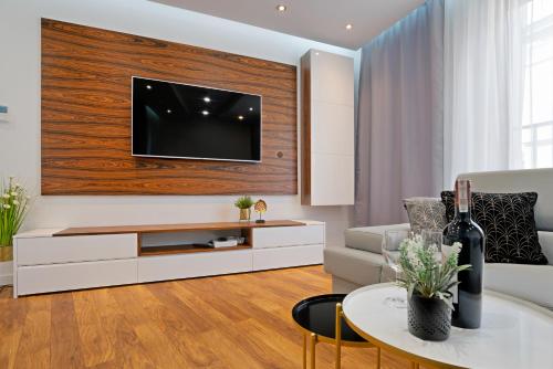 uma sala de estar com uma televisão na parede em Apartamenty Prestige Browar Lubicz Stare Miasto em Cracóvia