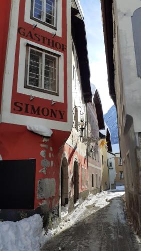 a building with a sign on the side of a street at Gasthof Simony Hallstatt B&B in Hallstatt
