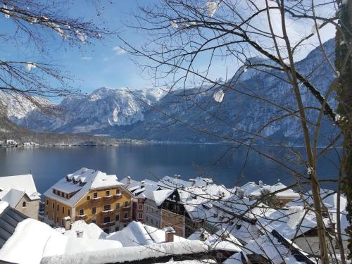 a city covered in snow with mountains in the background at Gasthof Simony Hallstatt B&B in Hallstatt