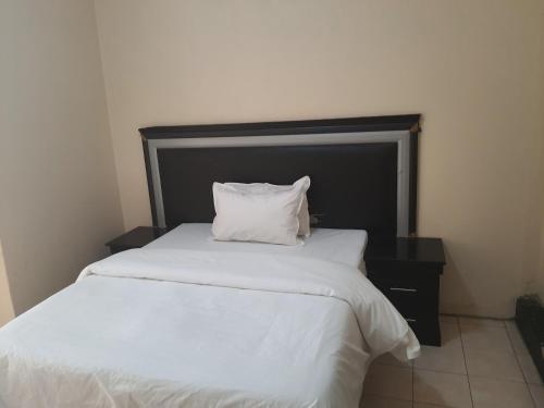 a bed with a white pillow on top of it at Miami guest house in Vereeniging