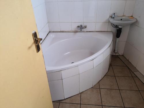 a bath tub in a bathroom with a sink at Miami guest house in Vereeniging