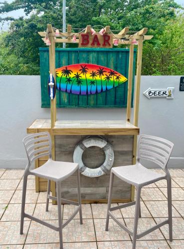 two chairs and a table with a bar on a patio at Walk to the Beach 2Min, Cozy, Boutique, Pool, Palmeras Del Mar Isabela in Isabela
