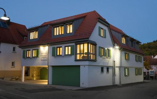 een wit en groen huis met een rood dak bij exNicrum Wein . Genuss . Hotel 