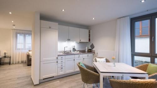 een keuken en eetkamer met een tafel en een tafel en stoelen bij exNicrum Wein . Genuss . Hotel 