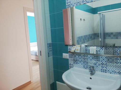 ein blau gefliestes Bad mit einem Waschbecken und einem Spiegel in der Unterkunft Il Borgo di Nonno Carlo in Caprioli