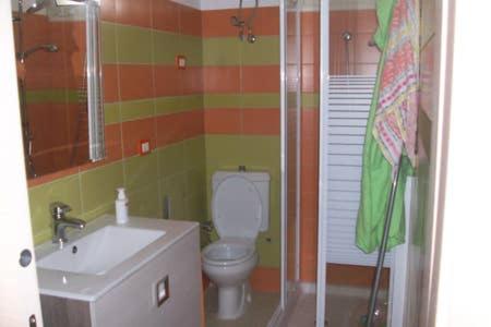 e bagno con servizi igienici, lavandino e doccia. di ColourHouse a Furci Siculo