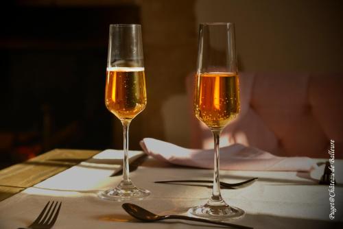 - deux verres de champagne assis sur une table dans l'établissement Chateau de Balleure, à Étrigny