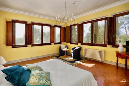 een grote kamer met een bed en een aantal ramen bij Villa del Parco Resort in San Baronto