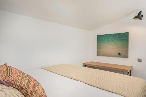 a white bedroom with a bed and a table at Ionian Village in Lixouri