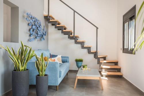 a living room with a blue couch and stairs at Ionian Village in Lixouri