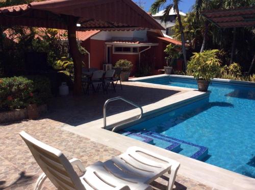 a swimming pool with two chairs next to a house at Villas Casa Carlos in La Abuela