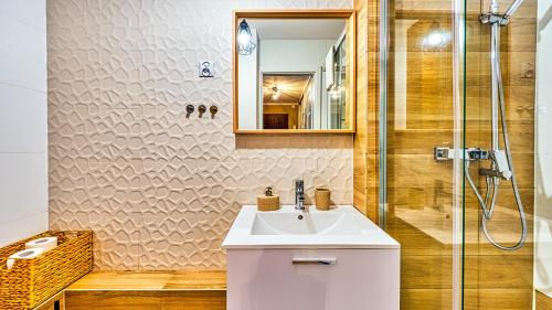 a bathroom with a sink and a shower at Apartament Emili - 5D Apartamenty in Szklarska Poręba