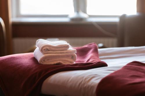 a pile of towels sitting on top of a bed at Cameo Boutique Hotell in Ystad
