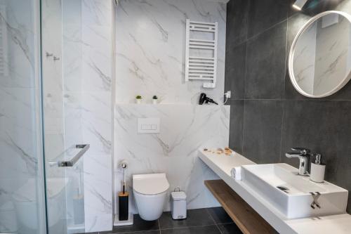 a bathroom with a sink and a toilet and a mirror at Stylchyn 90 Apartamenty nad Jeziorem Czorsztyńskim in Kluszkowce
