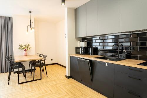a kitchen with a table and a dining room at Stylchyn 90 Apartamenty nad Jeziorem Czorsztyńskim in Kluszkowce