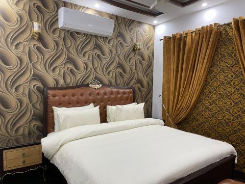 ラホールにあるRoyal Three-Bedroom Villa Dha Phase 6 Lahoreのベッドルーム1室(ベッド1台付)、壁に壁掛け式のマウンテンディッチャーが備わります。