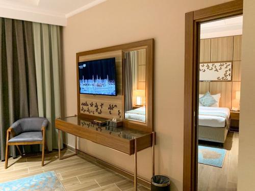 a hotel room with a vanity and a mirror at Midan Hotel & Suites Al Aziziya in Makkah
