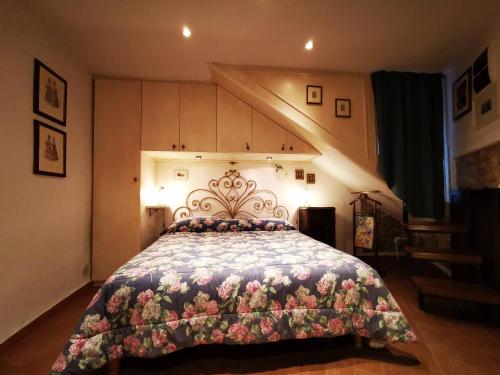 una camera da letto con un grande letto con un copriletto floreale di "Il Nido" a Sermoneta
