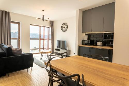 a kitchen and living room with a table and chairs at Stylchyn 90 Apartamenty nad Jeziorem Czorsztyńskim in Kluszkowce