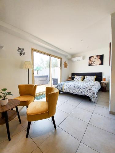 une chambre avec un lit, une table et des chaises dans l'établissement Lodge Casamance, à Solliès-Pont