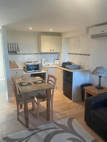 a kitchen and living room with a table and a dining room at Moorhead Country Holidays in Bideford