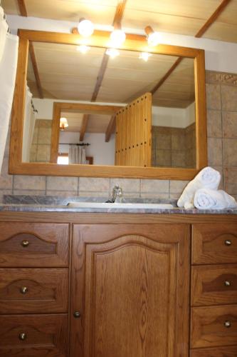 uma casa de banho com um lavatório e um espelho grande em finca son gallina con piscina y jardín en Sa Pobla, ideal para 6 personas em La Puebla