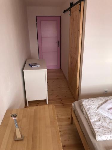 a bedroom with a bed and a pink door at Pension S láskou Karel Bezděz in Schloss Bösig