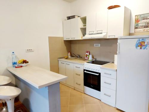 a kitchen with white cabinets and a white refrigerator at Red brick in Belgrade