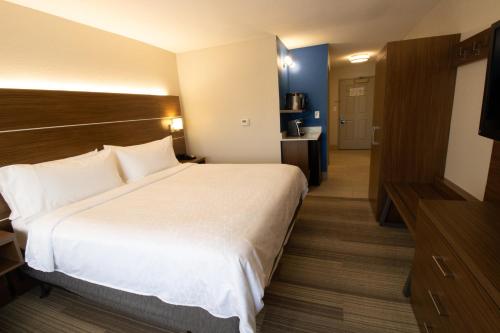 a hotel room with a large bed and a bathroom at Holiday Inn Express & Suites Manassas by IHG in Manassas