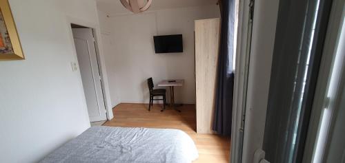 a bedroom with a bed and a desk with a chair at Hôtel de la poste in Saint-Valery-en-Caux