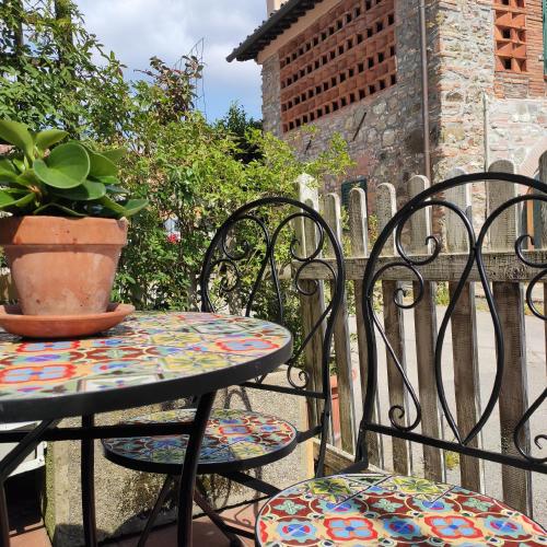 a table and chairs with a potted plant on a patio at Gipsy Maisonette in Lucca