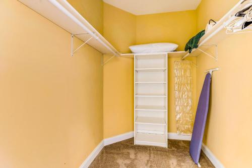 a closet with yellow walls and white shelves at South Beach in Ocean City