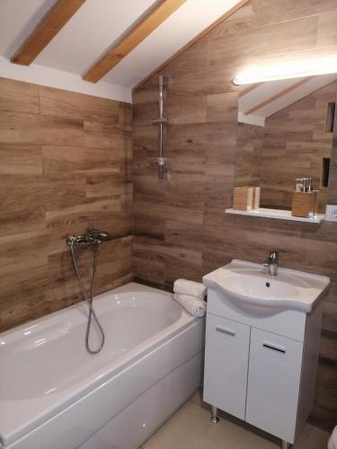 a bathroom with a white tub and a sink at Mountain village in Žabljak