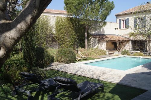 un cortile con piscina e due sedie a sdraio di Domaine de la Girafe a Eyragues