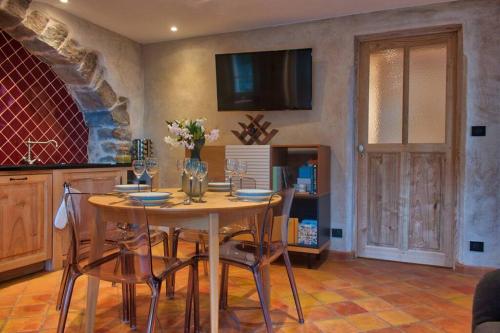 d'une salle à manger avec une table, des chaises et une télévision. dans l'établissement Appartement de charme à Olmeto, à Olmeto