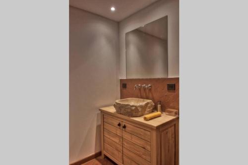 a bathroom with a sink and a wooden cabinet at Appartement de charme à Olmeto in Olmeto